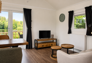 Soggiorno luminoso e moderno in chalet Beach House con vasca idromassaggio a Camping 't Veld, vista lago.