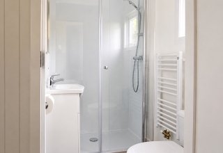 Bagno luminoso con cabina doccia, lavabo e termoarredo nel Beach house chalet al Camping 't Veld.