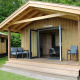 Træhytte med overdækket terrasse og havemøbler i grønne omgivelser ved Camping de Koeksebelt, Nederlandene.