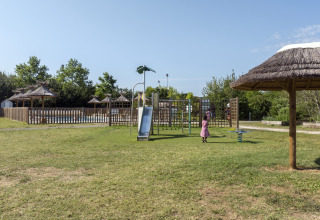 Children playing on a playground with a slide at Seasonova Camping Le Plan d’Eau holiday park, Nouvelle-Aquitaine, France.