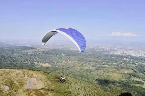 Paraglider soaring above the landscapes near Saint Yrieix sur Charente, Nouvelle-Aquitaine, France.