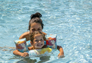 Mother and daughter swimming together in the pool at Seasonova Camping Le Plan d’Eau, Nouvelle-Aquitaine, France.