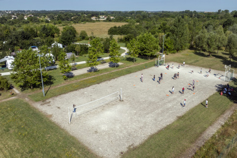 Aerial view of people playing sports on a field at Seasonova Camping Le Plan d’Eau, Nouvelle-Aquitaine, France.