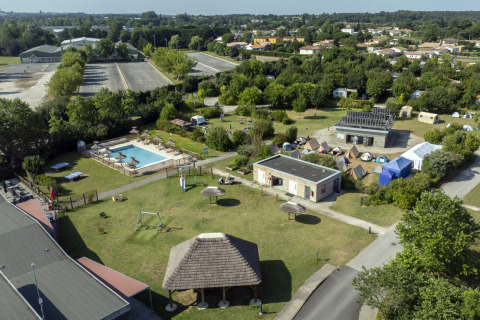 Aerial view of Seasonova Camping Le Plan d’Eau showing pool, tents, and green spaces in Nouvelle-Aquitaine.