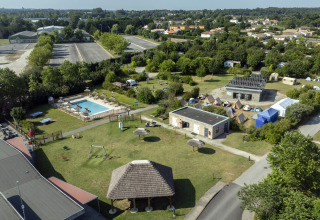 Aerial view of Seasonova Camping Le Plan d’Eau showing pool, tents, and green spaces in Nouvelle-Aquitaine.