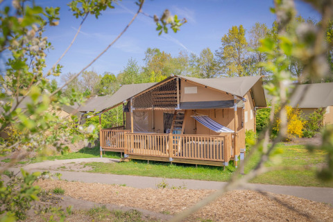 Tienda safari llamada Ranger Lodge en Holiday Park Sallandshoeve, Países Bajos, rodeada de naturaleza.