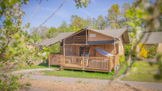 Safari tent Ranger Lodge in Holiday Park Sallandshoeve, Nederland, omgeven door bomen en natuur.