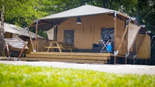 Tenda Safari Cottage all'Holiday Park Sallandshoeve nei Paesi Bassi con amaca, tavolo e barbecue.