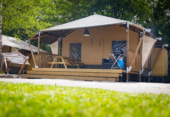 Tienda Safari Cottage en Holiday Park Sallandshoeve, Países Bajos, con hamaca, mesa y barbacoa.