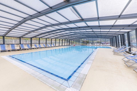 Überdachtes Schwimmbad mit Liegestühlen im Seasonova Camping Le Val de Coise, Pays de la Loire, Frankreich