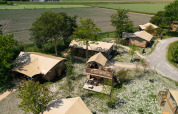 Vista aérea de la tienda Safari 2 en Lauwersmeer, Países Bajos, rodeada de árboles y campos tranquilos.