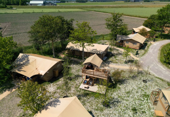 Vista aérea de la tienda Safari 2 en Lauwersmeer, Países Bajos, rodeada de árboles y campos tranquilos.