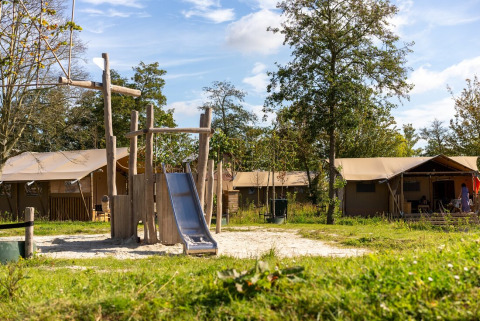 Parco giochi con scivolo e tende glamping al Lauwersmeer Holiday Park, Groningen, Paesi Bassi.