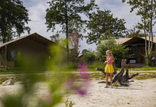 Ragazza con top rosa e gonna gialla al parco vacanze Lauwersmeer a Groningen, tende sullo sfondo.