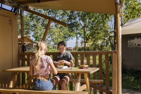 Dos mujeres sentadas en una mesa de madera al aire libre en Lauwersmeer, parque vacacional en Groningen, Países Bajos.