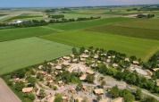 Vista aérea de un pueblo y campos cerca de Vierhuizen, Groningen, Países Bajos, rodeado de vegetación.