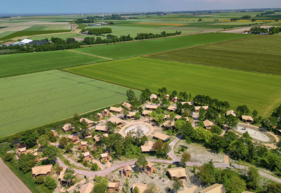 Vista aerea di un villaggio e campi vicino a Vierhuizen, Groningen, Paesi Bassi, immersi nel verde.