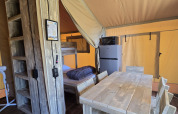 Interieur van de safari tent ‘Slow Lodge’ op Camping Seasonova Lac de Bournazel, met eethoek en keuken.
