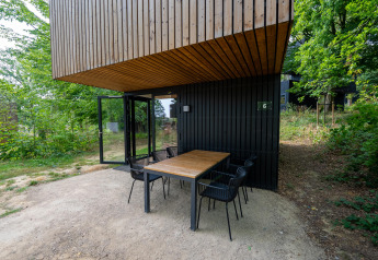 Moderner Sitzbereich im Freien am Woodland Lodge 6 in Gulpen, Niederlande, umgeben von Bäumen.