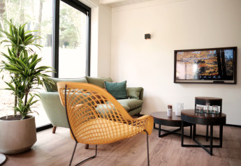 Moderne leefruimte in Woodland Lodge 6 in Gulpen, Nederland, met stijlvolle meubels en grote ramen.