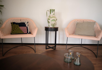 Sedie lounge moderne, tavolino con vaso e cuscini presso Timber Lodge 4 a Gulpen, Paesi Bassi.