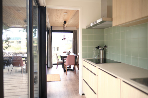 Cocina moderna y comedor en Timber Lodge 4, Gulpen, Países Bajos, con terraza y grandes ventanales.
