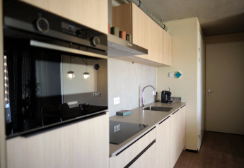 Moderne keuken in Hillside Comfort 4 lodge in Gulpen, Nederland, met oven, kookplaat en gootsteen.