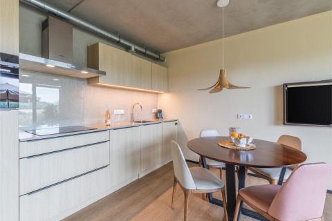 Cocina moderna y comedor en Hillside Royal 4 lodge en Gulpen, Países Bajos, con muebles de madera.