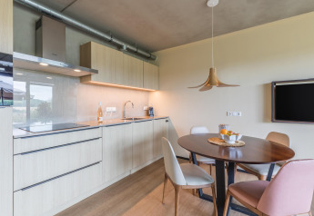 Cocina moderna y comedor en Hillside Royal 4 lodge en Gulpen, Países Bajos, con muebles de madera.