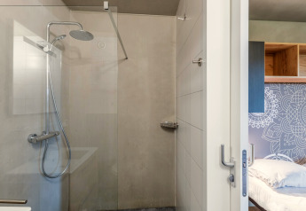 Moderna zona de ducha y dormitorio en el lodge Hillside Royal 4 en Gulpen, Países Bajos, con decoración sencilla.