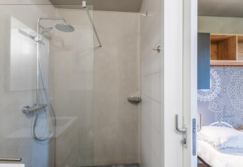 Douche moderne et chambre au lodge Hillside Royal 4 à Gulpen, Pays-Bas, au style épuré et fonctionnel.