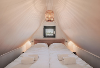 Schlafzimmer mit zwei Einzelbetten im Tiny House 2, Nieuwvliet-Bad, Niederlande. Gemütlicher Dachraum.