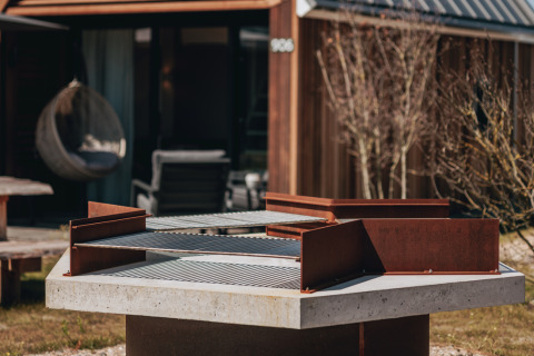 Udendørs grill i fokus foran et lille hus ved Tiny House 2, Nieuwvliet-Bad, Nederlandene.