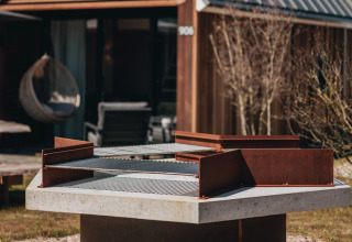Udendørs grill i fokus foran et lille hus ved Tiny House 2, Nieuwvliet-Bad, Nederlandene.