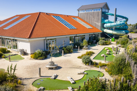 Udendørs minigolfbane og rutsjebane ved feriepark i Nieuwvliet-Bad, Zeeland, Holland, på en solrig dag.