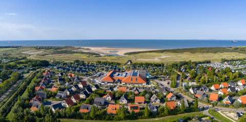 Aerial view of Nieuwvliet-Bad holiday park in Zeeland, Netherlands, with the coastline and sea visible.