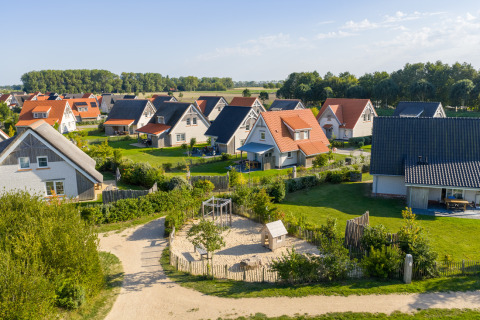 Luftbild eines Ferienparks in Nieuwvliet-Bad, Zeeland, Niederlande, mit gemütlichen Häusern und Garten.