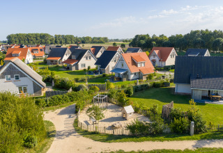 Luftbild eines Ferienparks in Nieuwvliet-Bad, Zeeland, Niederlande, mit gemütlichen Häusern und Garten.