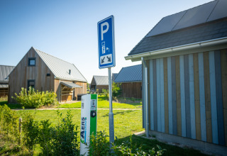 Elbil-ladestation og parkeringsskilt ved sommerhuse i Nieuwvliet-Bad feriepark, Zeeland, Holland.