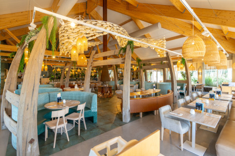 Lysfyldt restaurant med træbjælker og moderne indretning i Nieuwvliet-Bad, Zeeland, Holland.