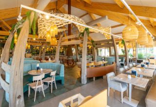 Lysfyldt restaurant med træbjælker og moderne indretning i Nieuwvliet-Bad, Zeeland, Holland.