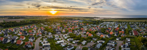 Luftfoto af ferieparken Nieuwvliet-Bad i Zeeland, Holland, ved solnedgang med huse og grønne områder.