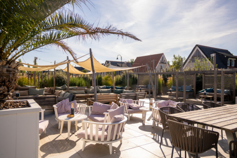 Gemütliche Außenterrasse mit Loungesesseln und Sonnensegeln im Nieuwvliet-Bad Ferienpark in Zeeland.