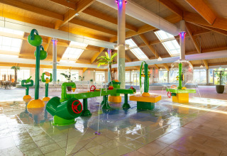Indendørs vandlegeplads i Nieuwvliet-Bad feriepark i Zeeland, Holland med farverige legeredskaber.