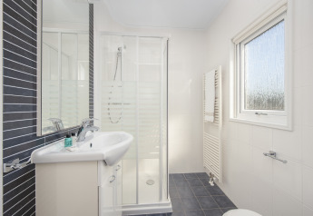 Salle de bain moderne à Meerkoet 4, Giethoorn, Pays-Bas, avec douche et grande fenêtre.