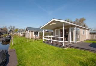 Feriehytter ved vandet i Giethoorn, Holland, med grøn græsplæne og træterrasse ved Meerkoet 4.
