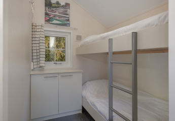 Petite chambre avec lits superposés, fenêtre, placard et échelle dans Tiny House 2 à Giethoorn, Pays-Bas.