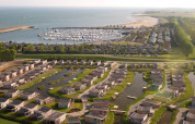Luftfoto af Water Village feriepark i Zeeland, Holland, med moderne boliger og lystbådehavn ved kysten.