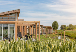 Moderne Ferienhäuser am Wasser im Water Village Park, Zeeland, Niederlande, umgeben von Natur.