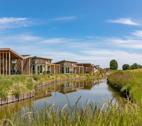 Moderne Ferienhäuser am Wasser im Water Village Ferienpark in Zeeland, Niederlande, bei sonnigem Wetter.